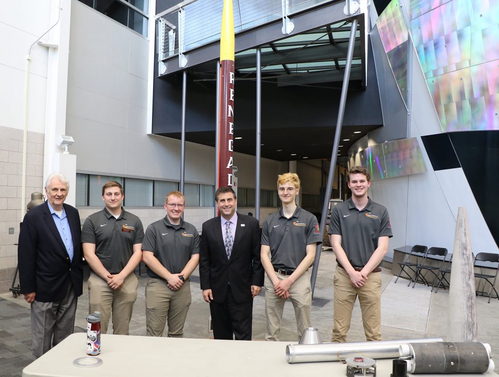NASA International Space Station director Joel Montalbano with members of the CyRoc team and Imperator rocket at an AerE display held during Montalbano's visit to the department
