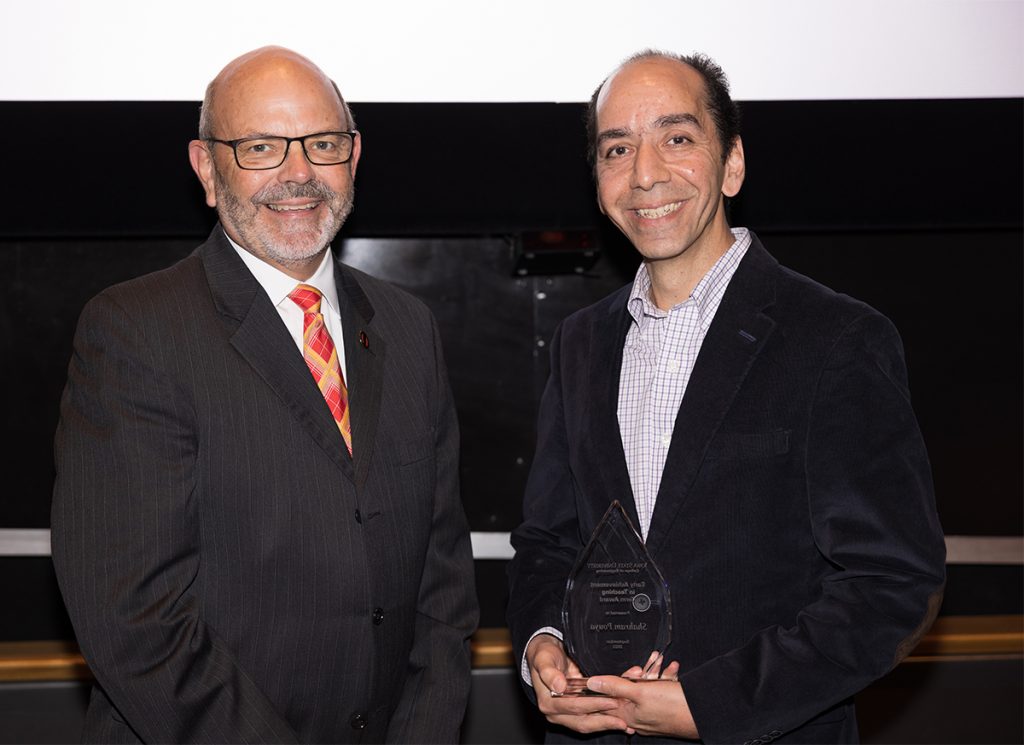 Shahram Pouya receives a plaque commemorating his award from Dean Sam Easterling at the 2022 College of Engineering Honors and Awards Ceremony.