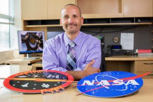 Gonzalez-Torres at desk with logos