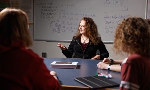 Kristin-Yvonne Rozier at desk talking to students