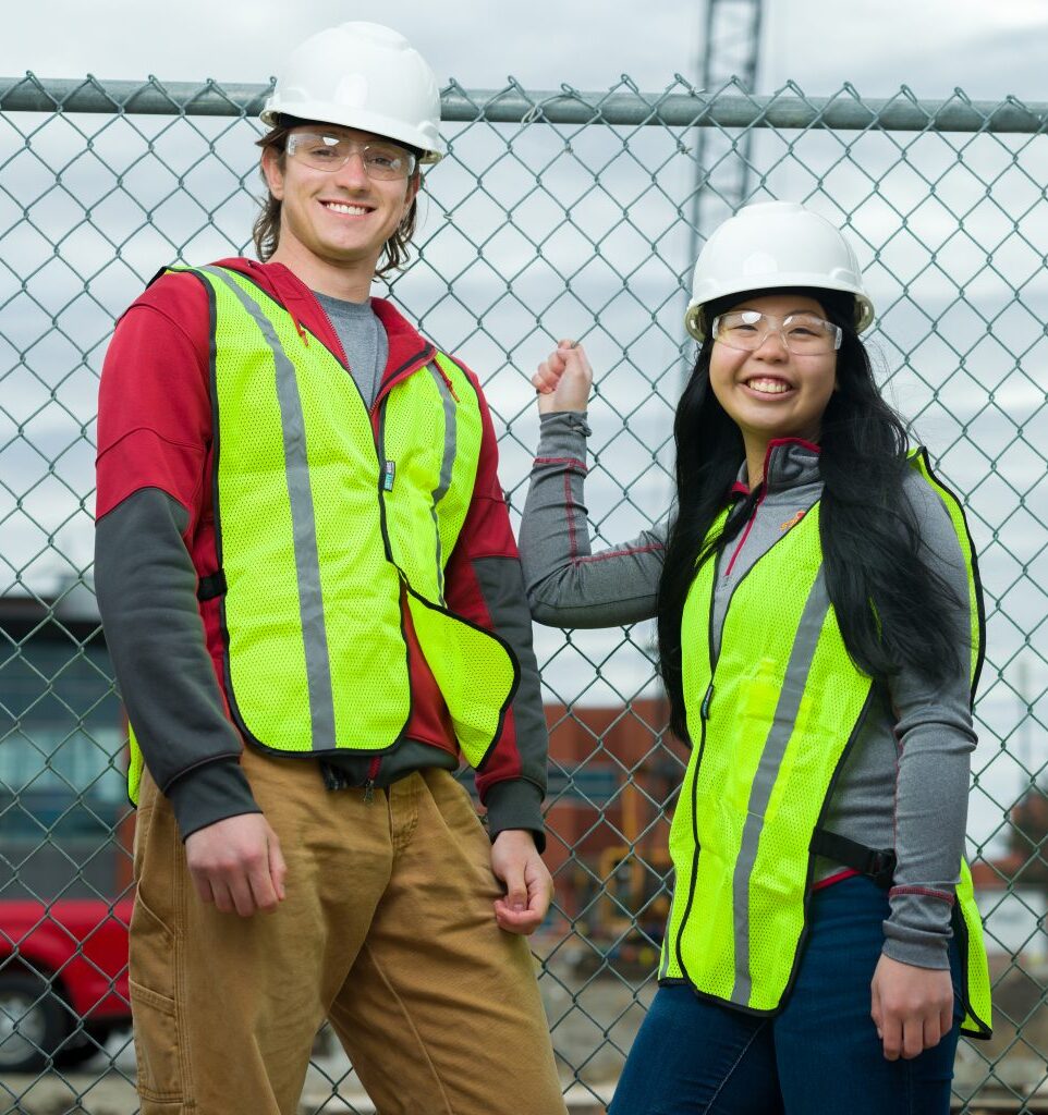 SafetyScan founders Phillip Gorni and Sarah NG pose for a picture with hard hats and reflective vests
